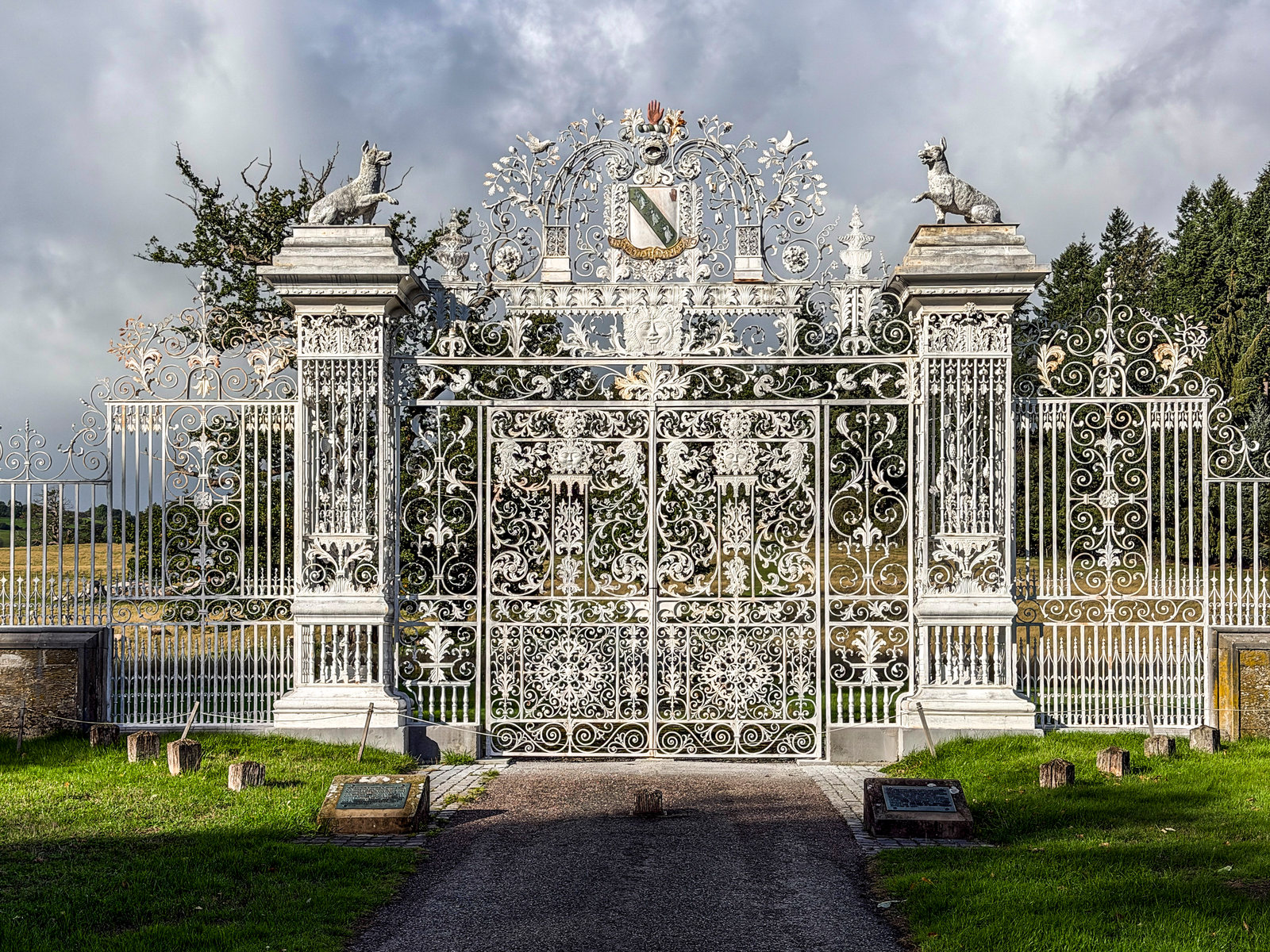 Ornamental iron entrance gates with decorated stone piers.