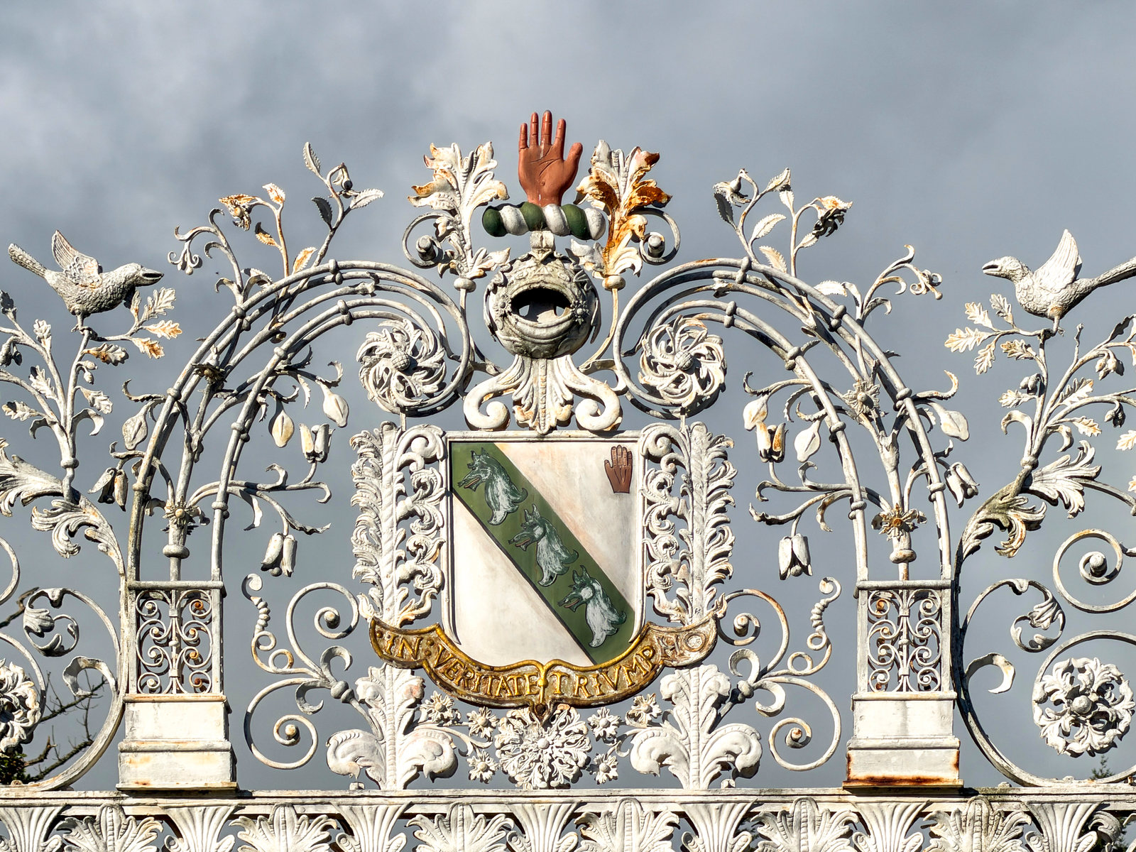 Heraldic details and scrolling ironwork on the entrance gates.